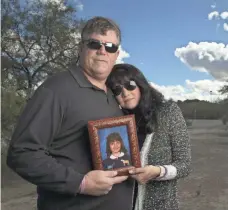  ?? DAVID WALLACE/USA TODAY NETWORK ?? John and Roxanna Green hold a photograph of their daughter, Christina-Taylor Green, at the Christina-Taylor Green Memorial River Park in 2015.