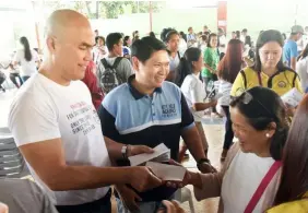  ?? Jun Jaso/Pampanga PIO ?? HEALTH ROADSHOW. Mayor Cris Garbo and Councilor Geld Aquino distribute Philhealth membership­s during the Philhealth Alaga Ka roadshow in Mabalacat City on Wednesday.—