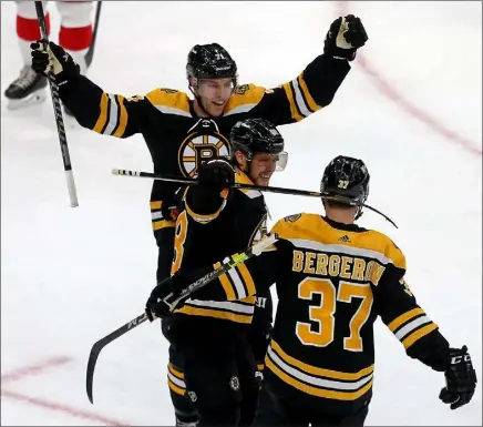  ?? MATT STONE / BOSTON Herald FILE ?? boston bruins Taylor Hall, left, and david Pastrnak celebrate with Patrice bergeron after bergeron’s second goal of the game against the detroit red Wings on Thursday.