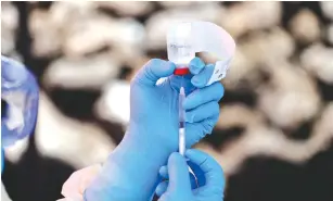  ?? (Baz Ratner/Reuters) ?? A HEALTH WORKER fills a syringe with the Ebola vaccine before injecting it to a patient in Goma, Democratic Republic of Congo, in August.