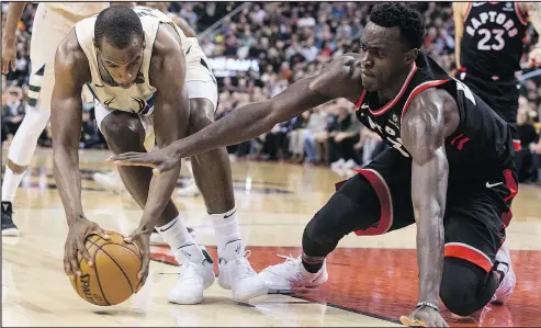  ?? CHRIS YOUNG/THE CANADIAN PRESS ?? Bucks’ Khris Middleton (left) battles for the ball with Raptors’ Pascal Siakam during Toronto’s loss on Friday night.