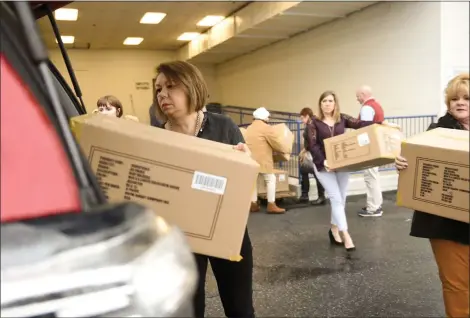  ?? LAUREN A. LITTLE — MEDIANEWS GROUP ?? Boscovs employees help the Hope Rescue Mission, the Reading YMCA, Opportunit­y House and Veterans Making a Difference load donations of Heat Holders socks at Boscov’s East on January 14.