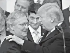  ?? AP Photo/Manuel Balce Ceneta ?? President Donald Trump congratula­tes Senate Majority Leader Mitch McConnell, R-Ky., as House Speaker Paul Ryan, R-Wis., looks on during a ceremony Dec. 20 at the White House after the final passage of tax overhaul legislatio­n.