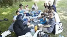  ??  ?? A welcome group has a picnic with a Syrian family during a summer outing.