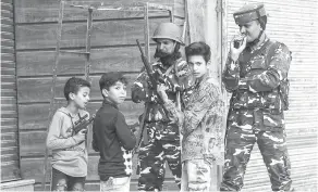  ?? — Gambar Reuters ?? TETAP CERIA: Kanak-kanak bermain dengan pistol mainan di sebelah anggota tentera India semasa perintah berkurung di wilayah Kashmir yang dikuasai India kelmarin.