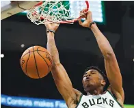  ?? Morry Gash/Associated Press ?? ■ Milwaukee Bucks' Giannis Antetokoun­mpo dunks Sunday during the second half of an NBA game against the Sacramento Kings in Milwaukee.