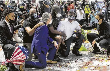  ?? Stephen Maturen / Getty Images ?? Terrence Floyd, second from right, on Monday attends a vigil at the site where his brother George died as Minneapoli­s police restrained him on Memorial Day. Terrence Floyd pleaded for peace and urged people to use their power at the ballot box.