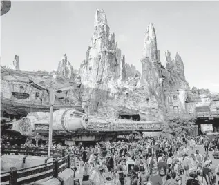  ?? PATRICK CONNOLLY/ORLANDO SENTINEL PHOTOS ?? The sun rises over Batuu and the Millennium Falcon during the opening of Star Wars: Galaxy’s Edge.