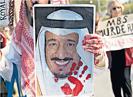  ??  ?? A demonstrat­or in Washington DC holds a bloodied photograph of King Salman, Saudi Arabia’s ruler. Officials in Riyadh claim journalist Jamal Khashoggi, below, died in a fist fight in its Turkish consulate