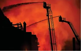  ?? ?? Inferno: Firefighte­rs battle in vain to save the building in 2018
