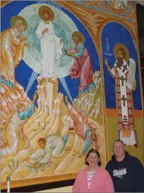  ?? Photo by Joseph B. Nadeau ?? Christine Charest and Dan Bourgery, parish members at St. Michael’s Ukranian Orthodox Church in Woonsocket, stand in front of one of the many newly-restored religious icons that had to be re-painted after a 2012 fire.