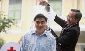  ?? — AFP ?? For a cause: Abhisit braving the ‘Ice Bucket Challenge’ to raise awareness of amyotrophi­c lateral sclerosis (ALS) in Bangkok.