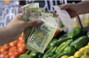  ?? — AFP photo ?? A woman pays for her items at a shop in Buenos Aires, Argentina. The Argentine government in January saw its first monthly budget surplus in nearly 12 years, as new President Javier Milei continues to push for strong spending cuts, the Economy Ministry announced.