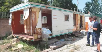  ?? Thomson Reuters Foundation ?? Roma community member Zarko Hadzovic shows members of the Roma rights group Associazio­ne 21 Luglio a pre-fabricated home destroyed by police in Rome in early July.