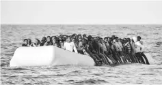  ??  ?? This file photo shows migrants and refugees on a rubber boat waiting to be rescued by the ship Topaz Responder run by Maltese NGO Moas and the Red Cross, off the Libyan coast in the Mediterran­ean Sea. — AFP photo