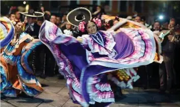  ??  ?? PENARI dan pemuzik tradisiona­l mariachi membuat persembaha­n di Plaza Garibaldi, Mexico City, Mexico. - AFP