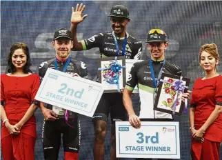  ??  ?? All smiles: Mekseb Debesay of Dimension Data (centre) acknowledg­ing the fans after winning the 174.4km Stage Four of the Le Tour de Langkawi yesterday. — Bernama