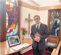  ?? ?? St Mary’s curate Ian Miller next to the book of condolence. Photo by Luke Douglas.