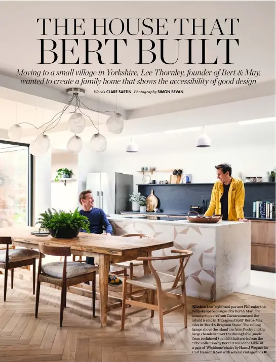  ??  ?? Kitchen Lee (right) and partner Phil enjoy this bespoke space designed by Bert & May. The countertop­s are from Caesarston­e and the island is clad in ‘Hexagonal Split’ Bert & May tiles in ‘Pearl & Brighton Stone’. The ceiling lamps above the island are from Pooky and the large chandelier over the dining table (made from reclaimed Spanish shutters) is from the ‘73V’ collection by Bocci. Around the table sit a pair of ‘Wishbone’ chairs by Hans J Wegner for Carl Hansen & Søn with several vintage finds