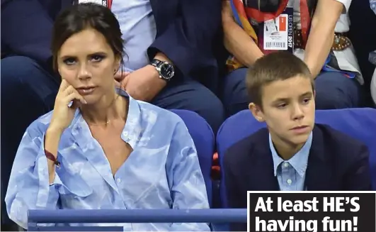  ??  ?? Less than gripped: Victoria Beckham and son Romeo during the Federer match