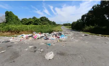  ??  ?? Rubbish being indiscrimi­nately dumped by the roadside in Kampung Bahagia Jaya.