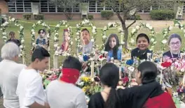 ?? JAE C. HONG/AP ?? People gather Monday at a memorial at Robb Elementary School in Uvalde, Texas, to pay their respects to the victims killed in last week’s school shooting.