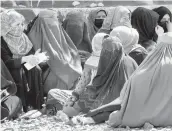  ?? EBRAHIM NOROOZI/AP ?? Afghan women dressed in head-to-toe clothing wait to receive food rations from a Saudi humanitari­an aid group April 25 in Kabul, Afghanista­n.