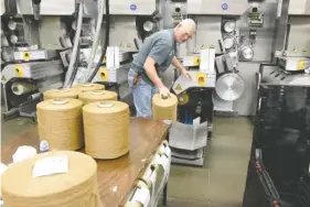  ?? STAFF FILE PHOTOS BY JOHN RAWLSTON ?? Jeff Smith unloads spools of carpet fiber from an extruder at J+J Flooring Group.