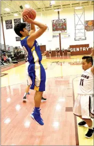  ?? Photo by Mike Eckels ?? Decatur’s Jimmy Mendoza fires a jumper over Gentry defender Auvan Vang during the Gentry-Decatur senior boys’ basketball matchup at Pioneer Gym in Gentry on Nov. 20. By Mike Eckels meckels@nwadg.com