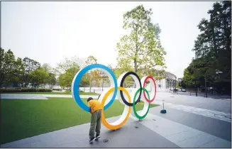  ?? (AP) ?? In this, April 21, 2020 file photo, a child plays at the Olympic rings in front of the New National Stadium in Tokyo.