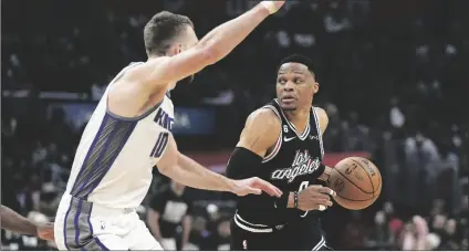  ?? MARK J. TERRILL/AP ?? LOS ANGELES CLIPPERS GUARD RUSSELL WESTBROOK (RIGHT) drives by Sacramento Kings forward Domantas Sabonis during the first half of a game on Friday in Los Angeles.