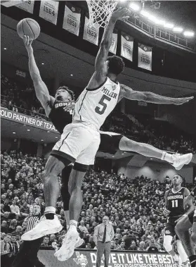  ?? Sam Craft / Associated Press ?? Gonzaga guard Admon Gilder, left, shoots as Texas A&M forward Emanuel Miller defends. Gilder starred at A&M before transferri­ng to Gonzaga.