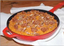  ?? Associated Press photo ?? This undated image released by Elizabeth Karmel shows a sweet potatoes dish with pecans and bourbon. A splash of bourbon is a very easy way to up the flavor ante and elevate your home cooking.