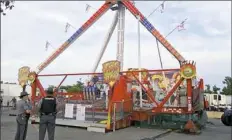  ?? Jim Woods/The Columbus Dispatch via AP ?? Authoritie­s stand near the Fire Ball amusement ride after the ride malfunctio­ned at the Ohio State Fair in Columbus, Ohio.