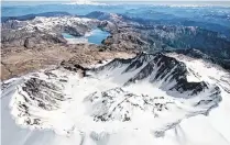  ?? DEAN J. KOEPFLER ?? Pictured is a view of the south rim of Mount Saint Helens, looking past a still venting lava dome north toward Spirit Lake and Mount Rainier.