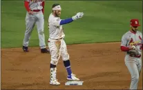  ?? LAURENCE KESTERSON - FOR THE ASSOCIATED PRESS ?? The Phillies’ Bryce Harper gestures from second base to the team’s dugout after hitting an RBI double during the second inning against the Cardinals on Friday.