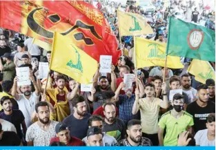  ?? – AFP ?? BEIRUT: Supporters of Lebanese Shiite movements Hezbollah and Amal brandish flags and placards as they protest a statement made by the US ambassador at a rally in the southern suburbs of the capital on Sunday.