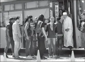  ?? AP ?? Syrian rebel fighters board a bus Monday as they leave the besieged rebel-held neighborho­od of al-Waer in the city of Homs.