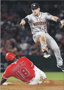 ?? Wally Skalij Los Angeles Times ?? ALEX BREGMAN of the Astros turns a double play as the Angels’ Brian Goodwin tries to break it up in the third inning at Angel Stadium. The Angels have taken the first two of the series.