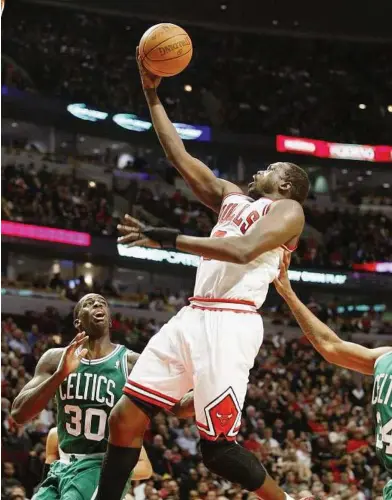  ??  ?? In form: Chicago Bulls’ Luol Deng (9) goes to the basket as Boston Celtics’ Brandon Bass (30) defends in the second half of their NBA game in Chicago on Thursday. — Reuters