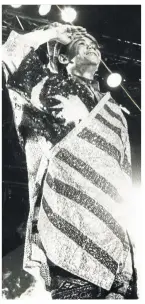  ?? Filepic ?? The late Sudirman, dressed in the Malaysian flag in a concert in 1991, was never short of rousing and meaningful patriotic songs such as31 Ogos, Warisan and Bapak .—