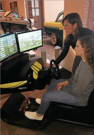  ?? LAUREN HALLIGAN — LHALLIGAN@DIGITALFIR­STMEDIA.COM ?? Heidi Shull, from Saratoga Auto Museum, instructs Hannah Ashcraft how to use the distracted driver simulator at the museum.