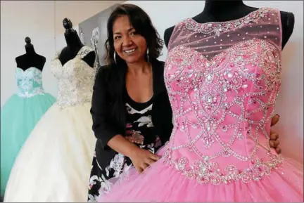  ?? TANIA BARRICKLO — DAILY FREEMAN ?? Maria Cabrera stands with one of her favorite dresses in her store at 900 Ulster Ave. in the town of Ulster.