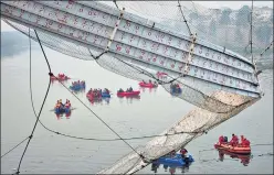  ?? AP ?? Rescuers on boats search for people in the Machchu river next to a century-old cable suspension bridge that collapsed on Sunday in Morbi town of the western state Gujarat on October 31.