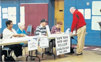  ?? ANGELA ROWLINGS / BOSTON HERALD ?? STEP RIGHT UP: Voters check in at the polling place at Holy Name Parish School gym in West Roxbury on Tuesday.