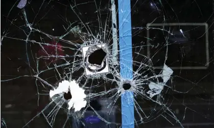  ?? Photograph: Michael Perez/AP ?? A storefront window with bullet holes is seen at the scene of a fatal overnight shooting on South Street in Philadelph­ia on Sunday.