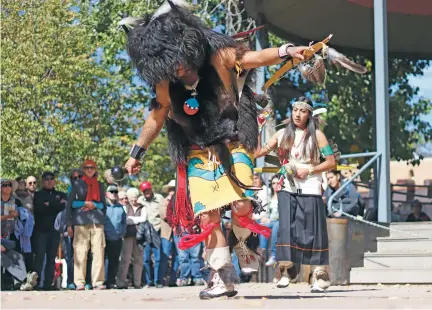  ?? DANIELLE PROKOP/THE NEW MEXICAN ?? Troy Tefoya, 24, dances the Buffalo Dance with his sister Amanda Kedge, 29, in Saturday’s opening ceremony for Indigenous Peoples Day. Celebratio­ns culminate with Monday’s events on the Plaza.