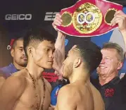  ??  ?? IBF superflywe­ight champion Jerwin Ancajas (left) stares down Mexican challenger Alejandro Santiago at the weigh-in for their fight while supervisor Peter Podgorski holds up the title belt.