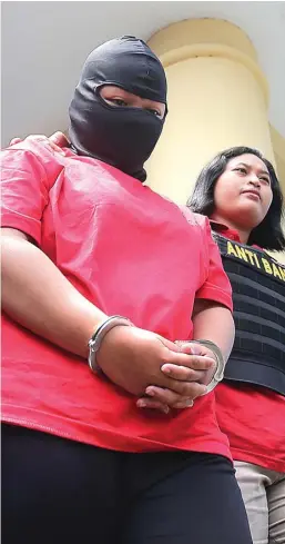 ?? GALIH COKRO/JAWA POS ?? MOTIF CEMBURU: Desy Ayu Indriani, tersangka pembunuh suaminya, Fendik Tri Oktasari, saat dirilis di Mapolsek Karang Pilang kemarin (31/3).
