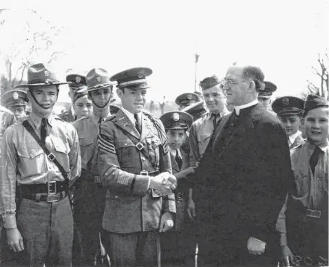  ?? UTSA Special Collection­s ?? Father Edward J. Flanagan greets Cadet Lt. William H. Storm at Peacock Military Academy on May 19, 1939. The founder of Boys Town visited at the request of John H. Brinkley, the controvers­ial doctor whose son was then a Peacock student.